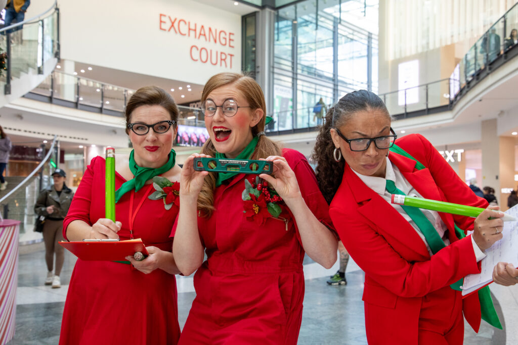 Three women dressed as happy elves spreading Christmas Cheer