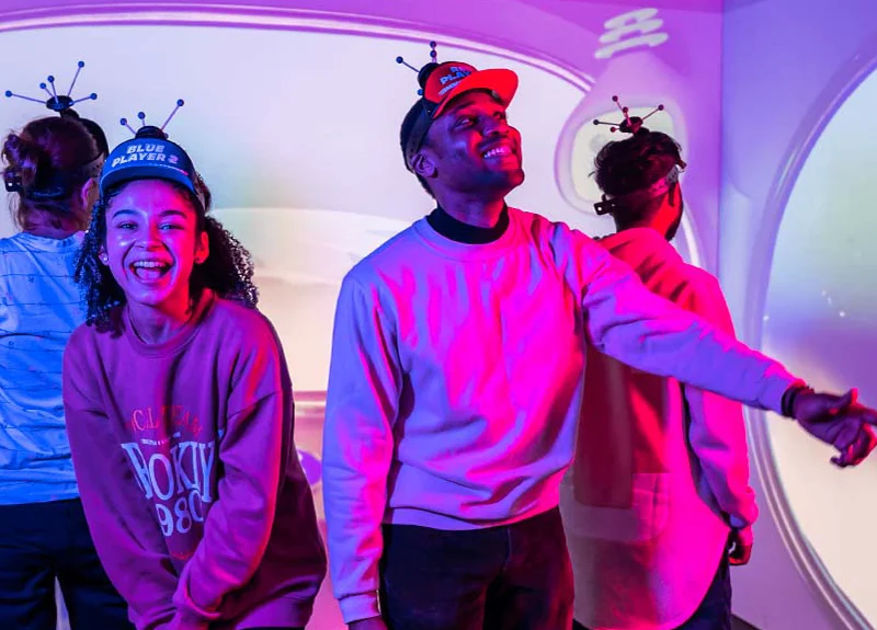 A group of 4 people playing immersive and interactive games.