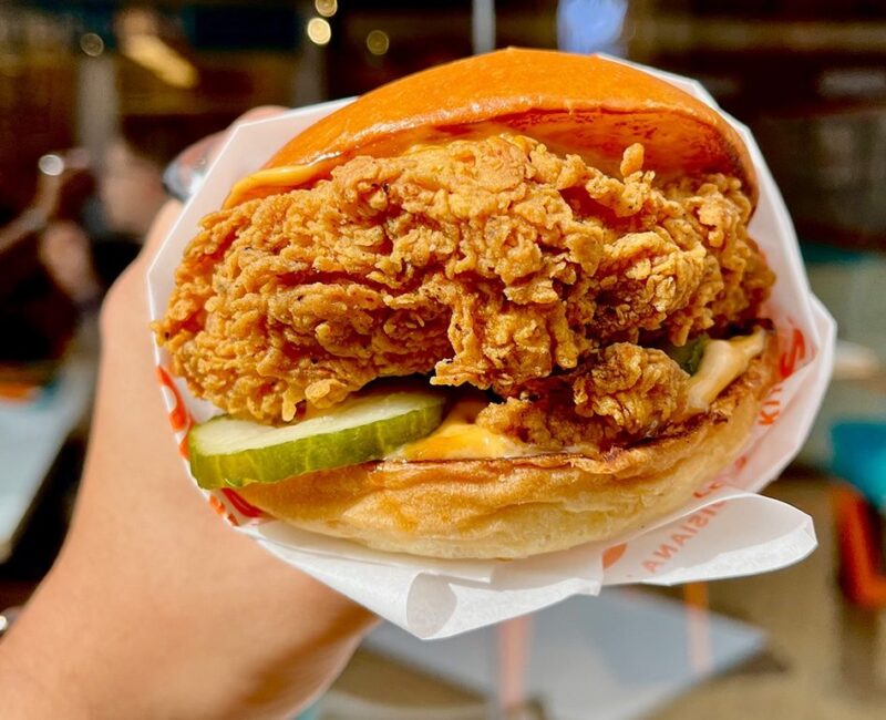 Someone holding a Popeyes chicken burger